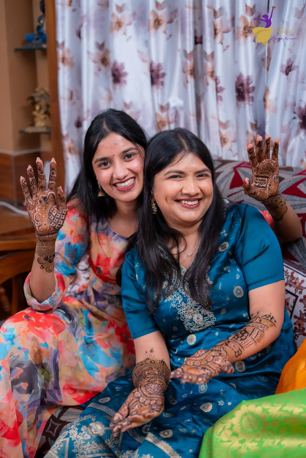 Priyanka laughing beside a cousin as they show off their henna