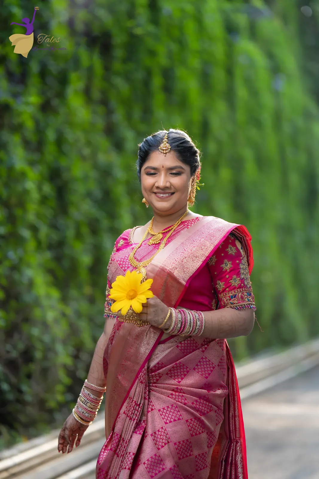 Full-length sunrise bridal portrait of Priyanka beside a green wall