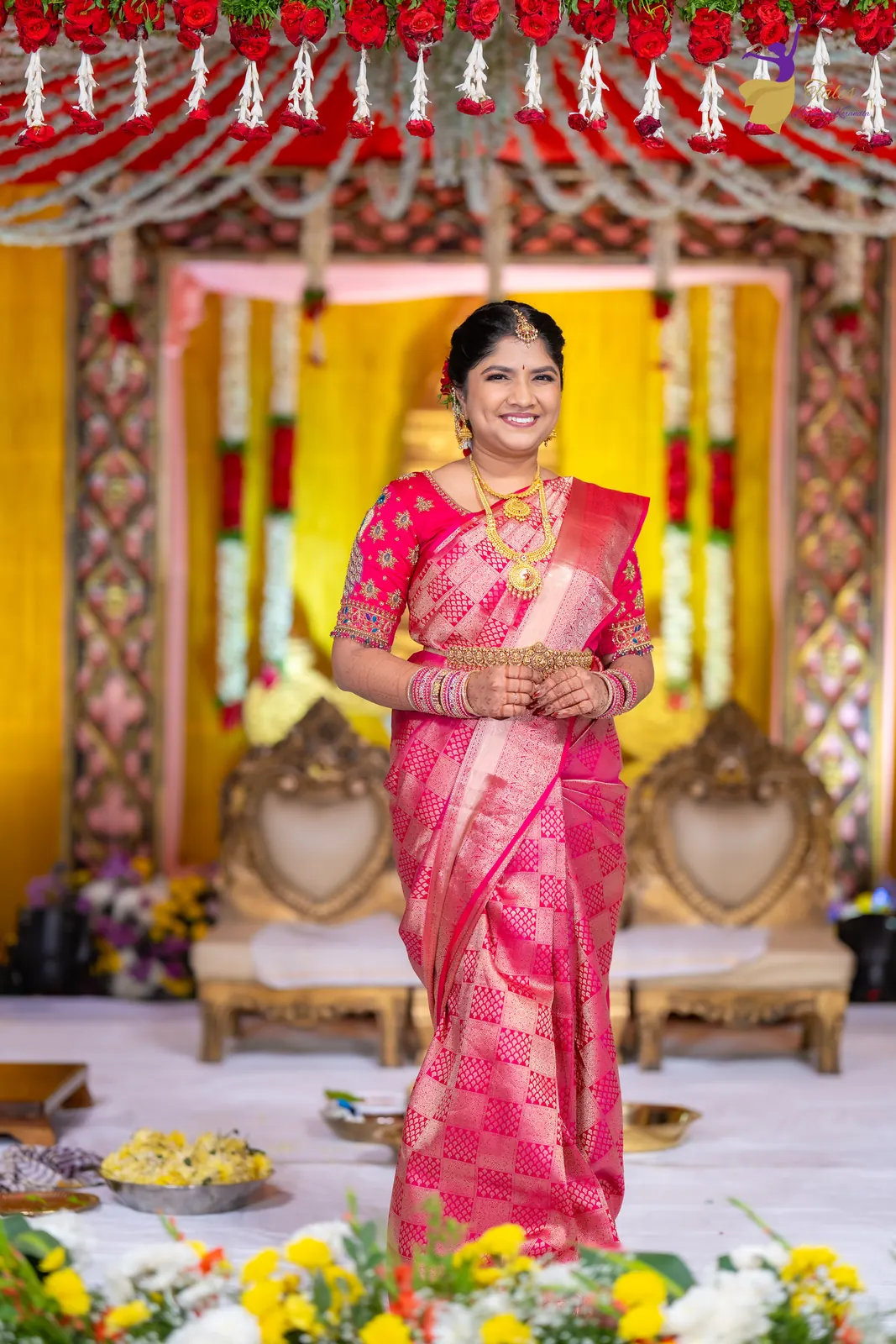 Bridal portrait of Priyanka in pink silk standing in front of the mandap