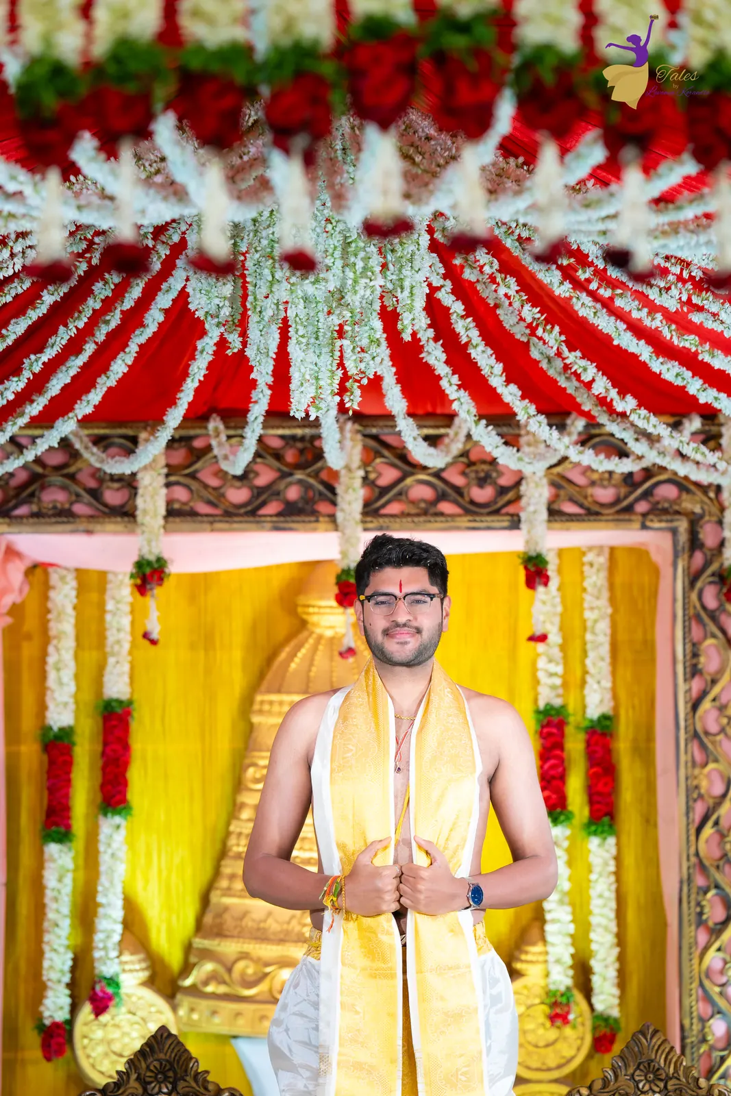 Aditya arriving at the mandap in a yellow shawl, hands folded