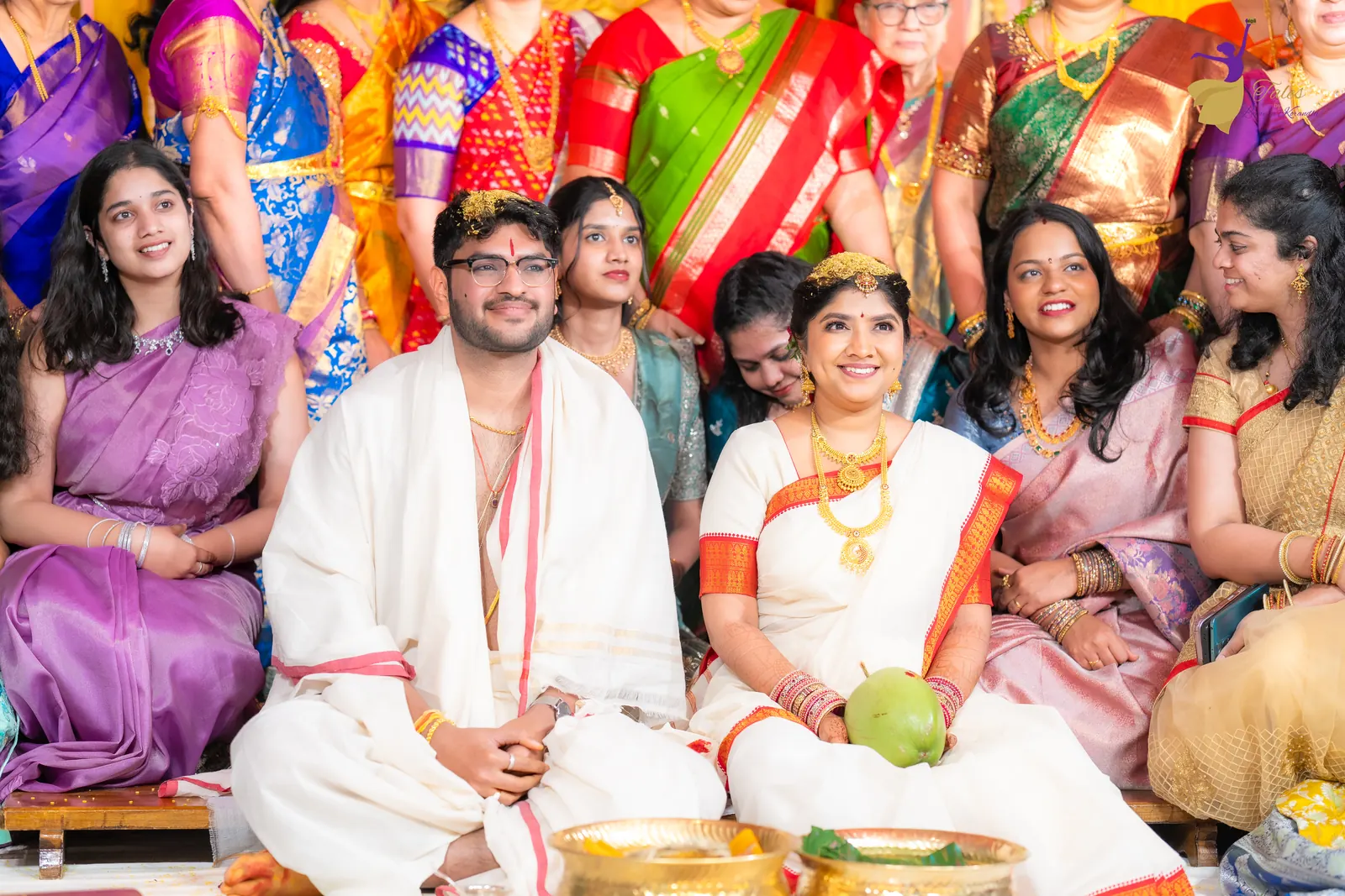 Aditya and Priyanka seated at the mandap as smiling cousins gather behind them
