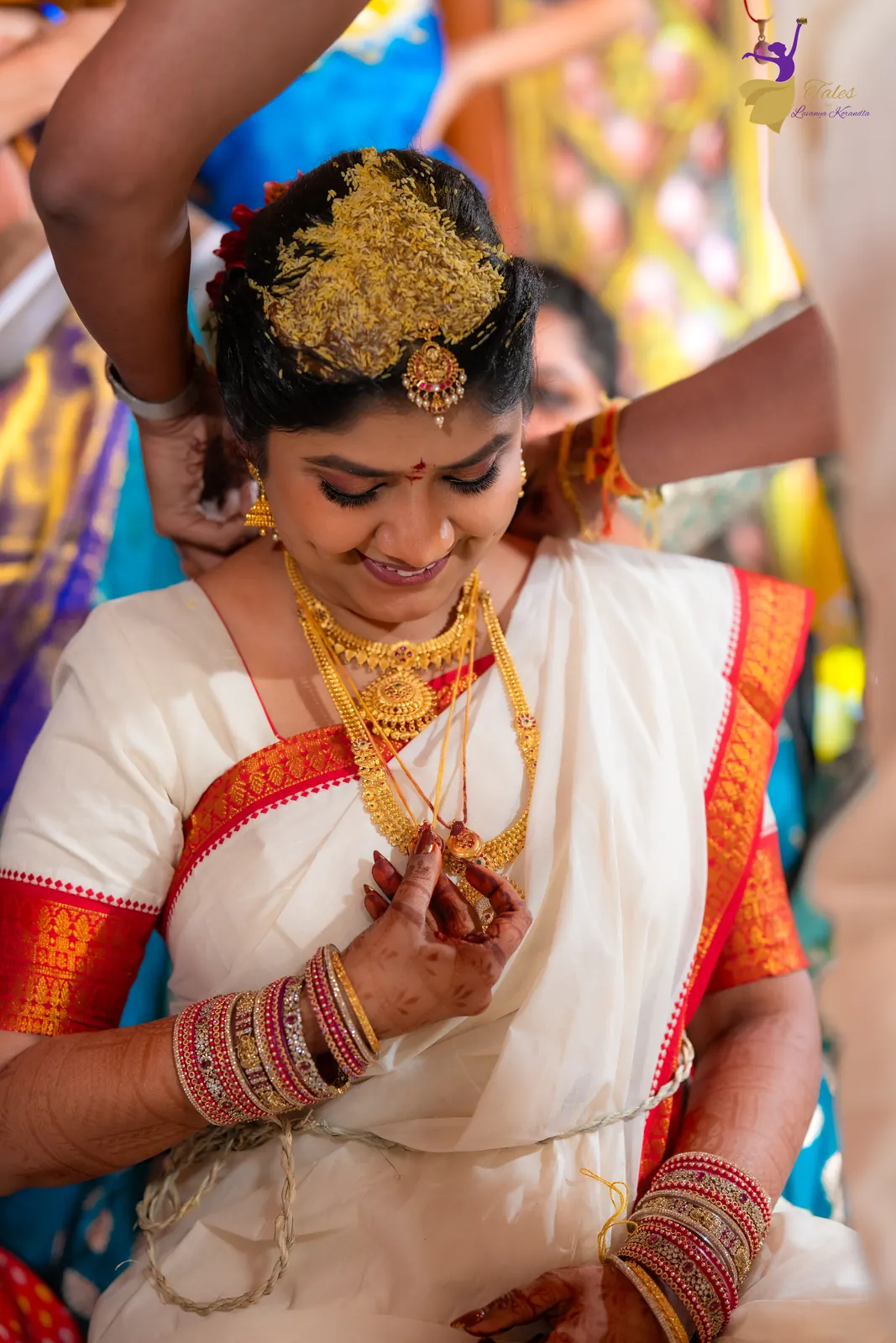 Priyanka smiling as the mangalsutra is fastened, wearing bashikam and gold jewellery