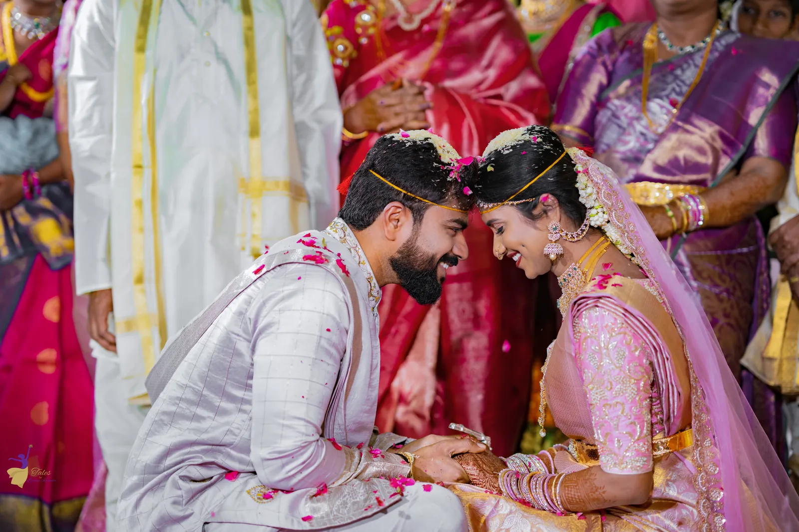 Bride and groom with bashikam touching foreheads and smiling during a Telugu wedding ritual