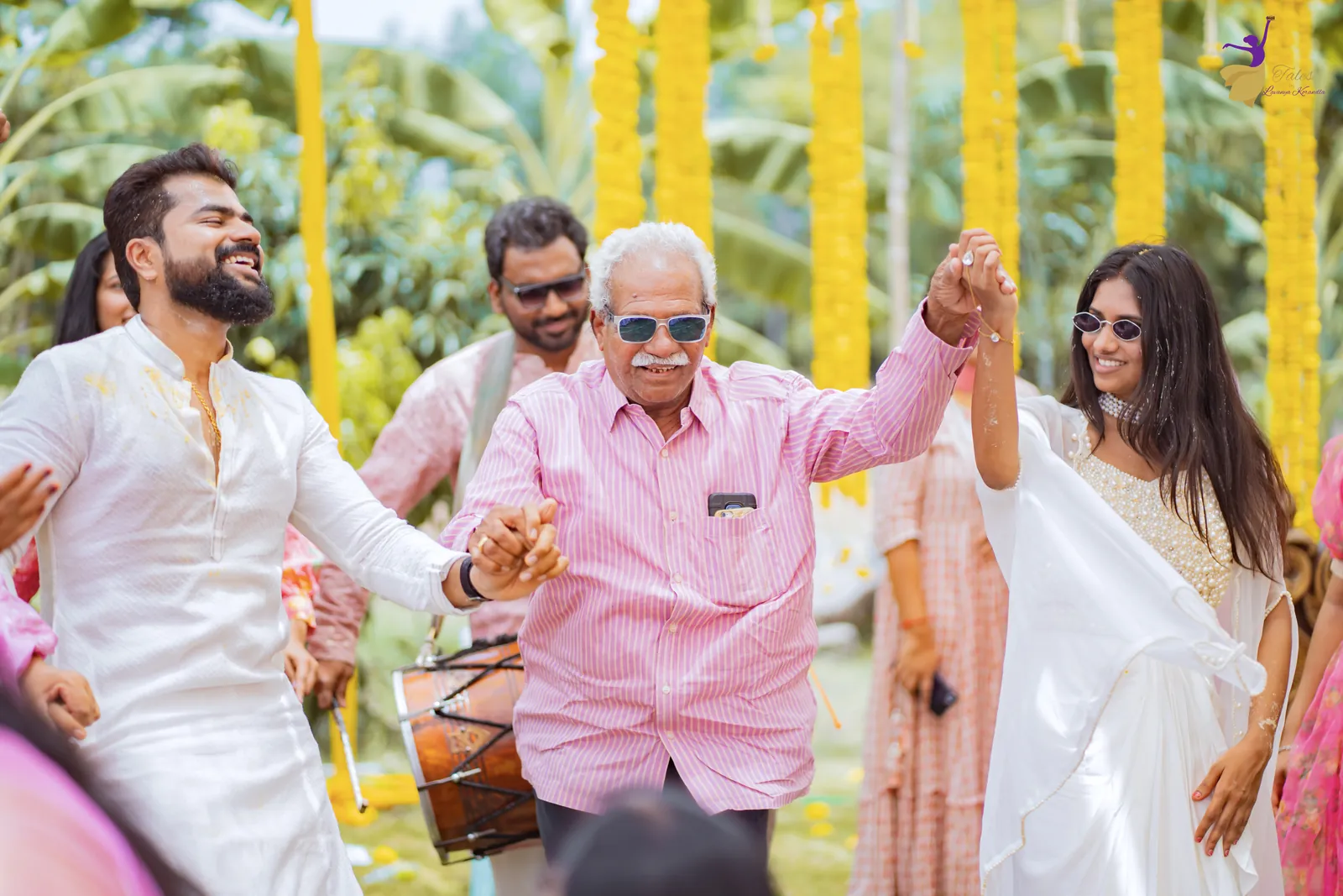 The groom dancing with family and cousins under marigold strings as the dhol plays