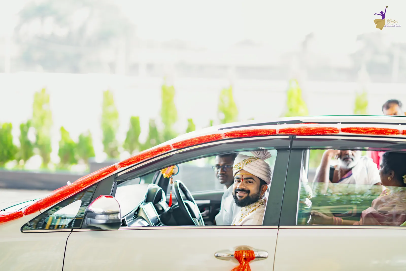 The groom arriving at the venue in a flower-decorated car