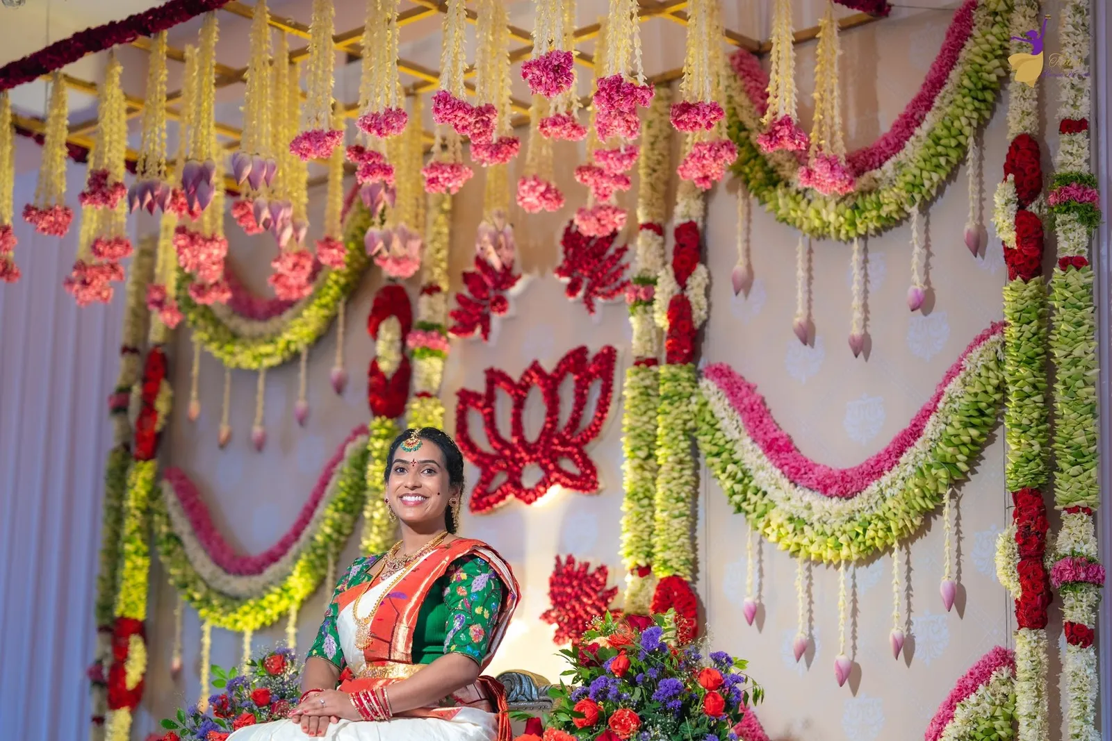 Wide view of Priya on the ornate Pellikuthuru floral stage