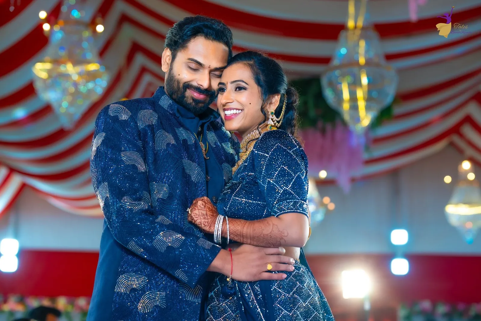 Manoj and Priya smiling at their midnight-blue pre-reception