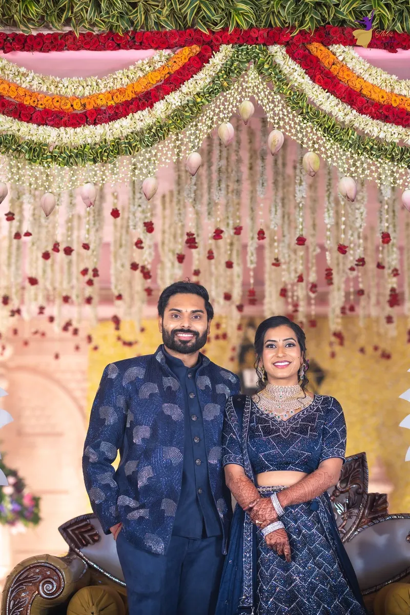Manoj and Priya in midnight blue at their pre-reception floral stage, Amalapuram