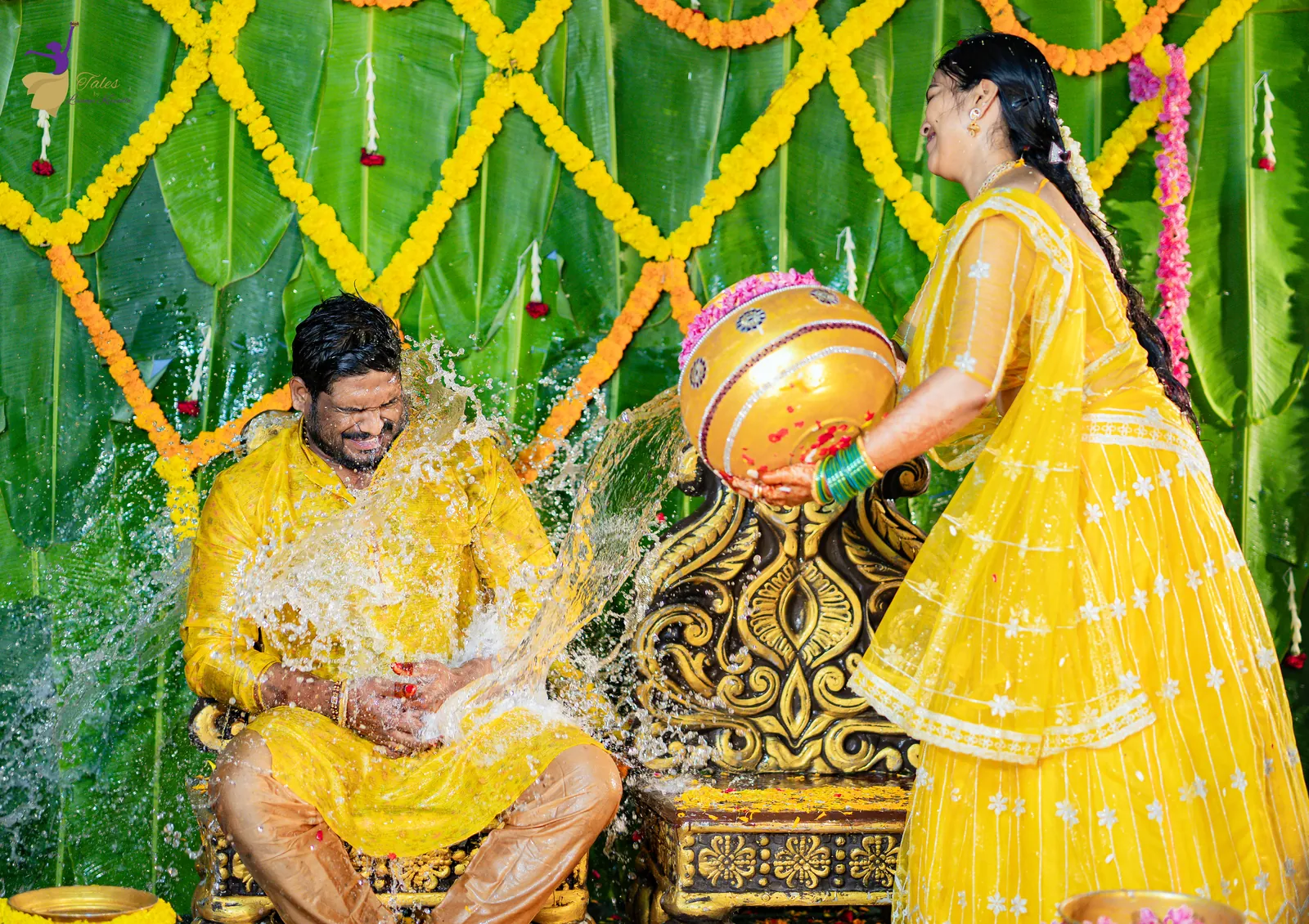 Anuhya pouring a pot of water over a laughing Ravinder at their haldi celebration