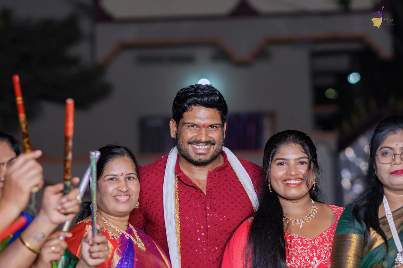 Ravinder laughing with his cousins and aunts holding dandiya sticks at the mehendi night