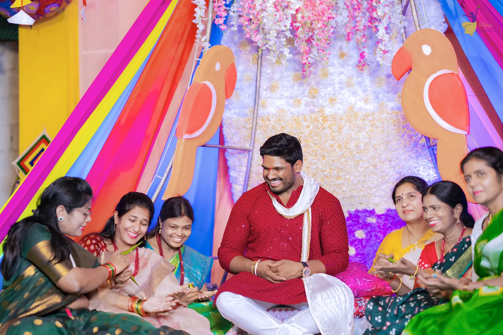 Ravinder seated on the colourful mehendi stage, laughing as cousins show off their mehendi