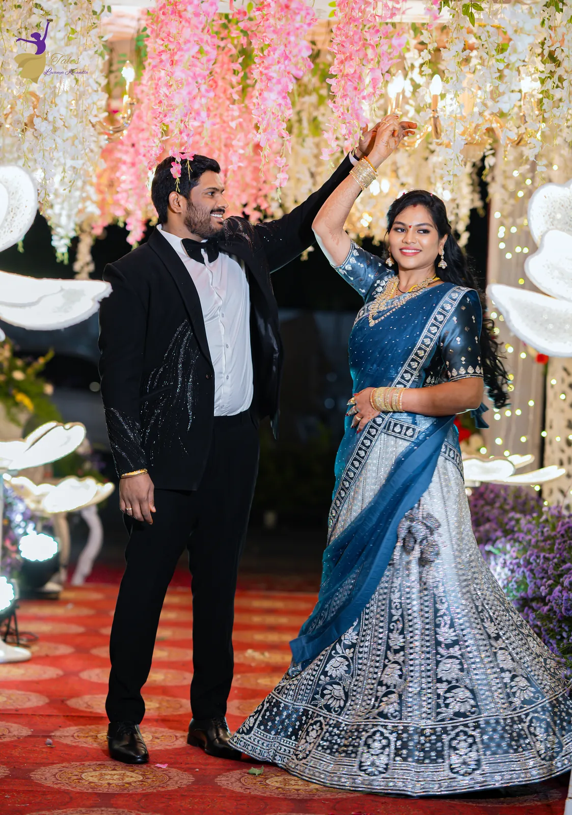 Ravinder and Anuhya in a playful dance pose on the reception floor