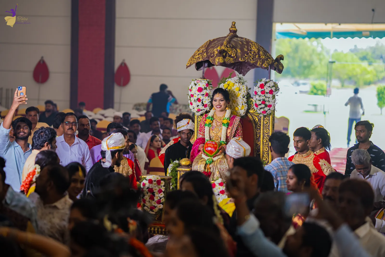 Wide view of the wedding hall packed with guests as the bride’s palanquin arrives