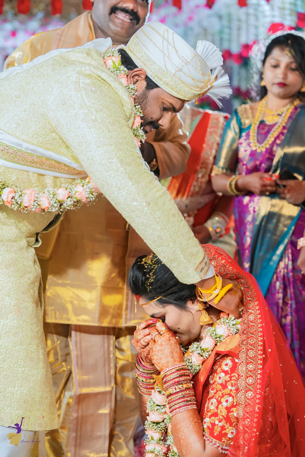 Ravinder tying the thali (mangalsutra) around Anuhya’s neck as family looks on