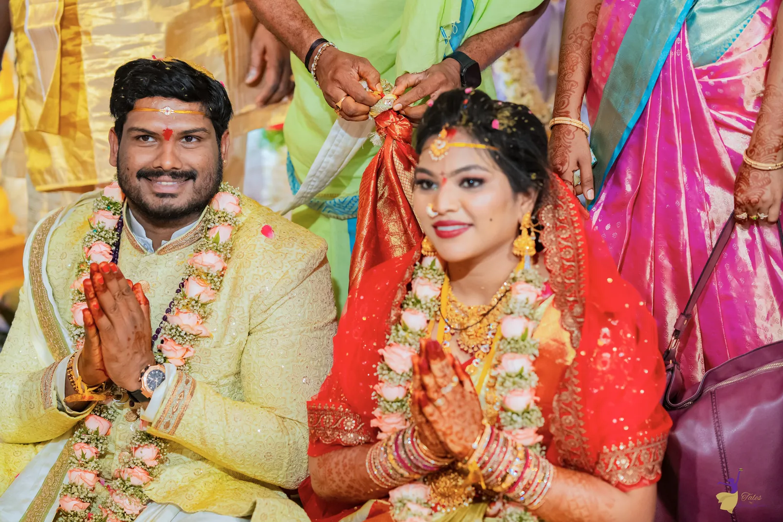 Ravinder and Anuhya seated together with folded hands, smiling as the rituals conclude