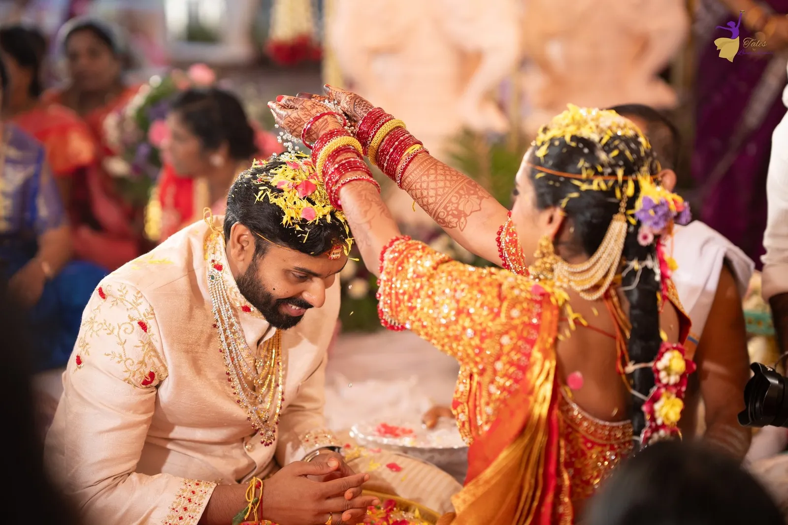 Priya pouring grains over Manoj during a joyous wedding ritual