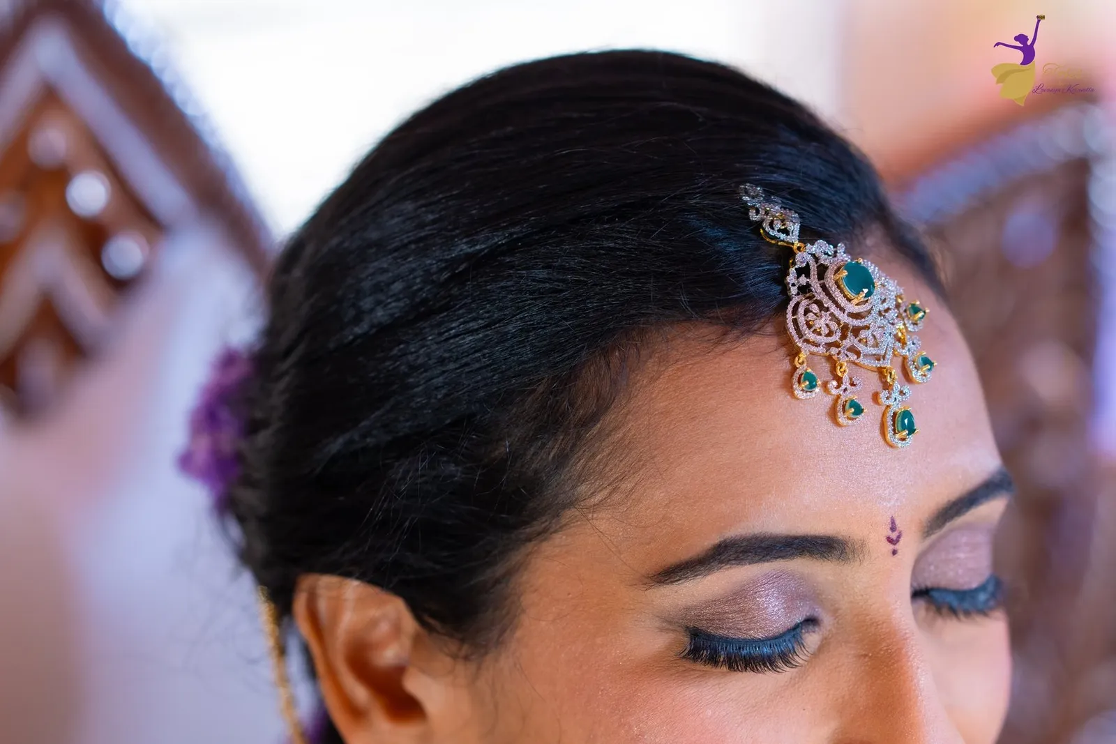 Bridal close-up of Priya with gold and green-stone maang tikka