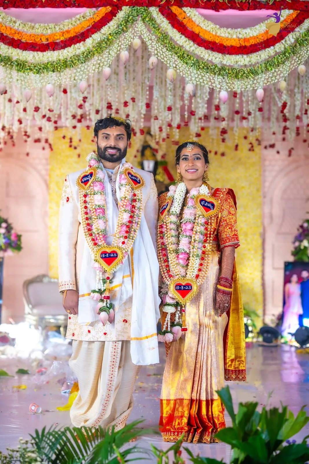 Couple on their Telugu wedding day before a floral stage, Amalapuram