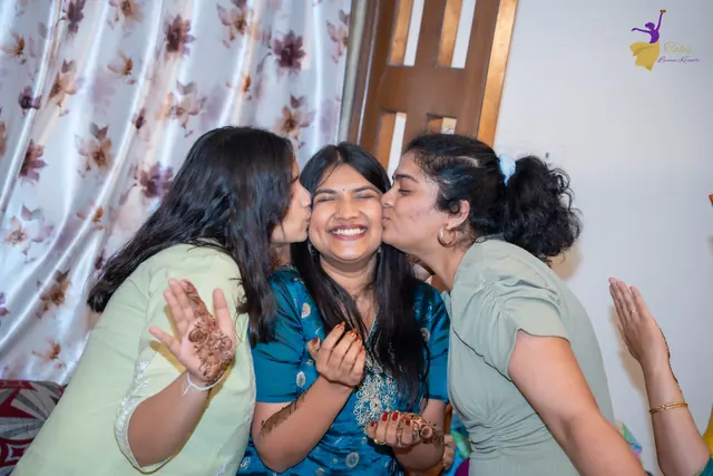 Priyanka laughing as two friends kiss her cheeks at her mehendi, Hyderabad