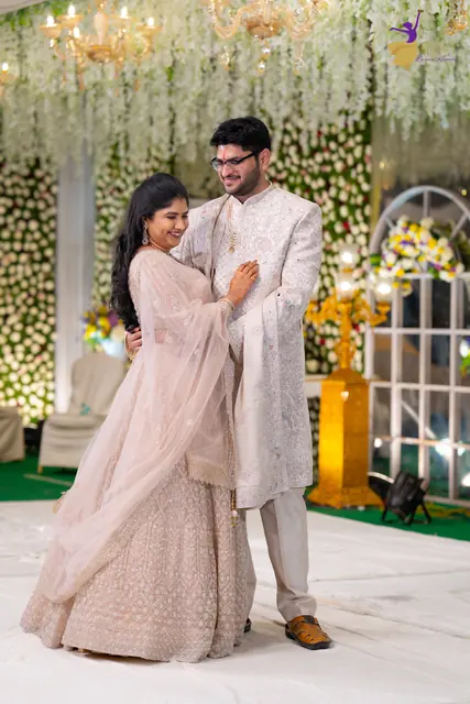 Aditya and Priyanka posing together on their floral reception stage, Hyderabad