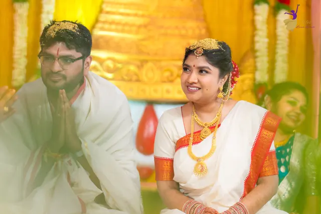 Aditya and Priyanka seated together during the wedding rituals, soft focus