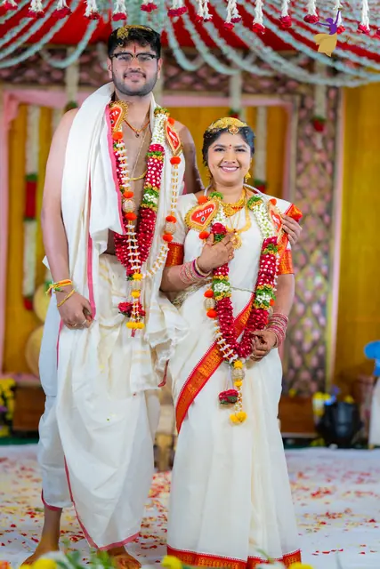 Newlyweds Aditya and Priyanka in white and red silks at the mandap, Hyderabad