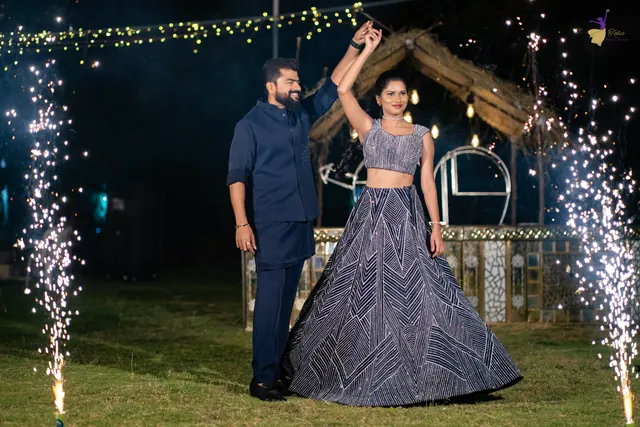 Bride twirling with the groom between cold sparklers under fairy lights