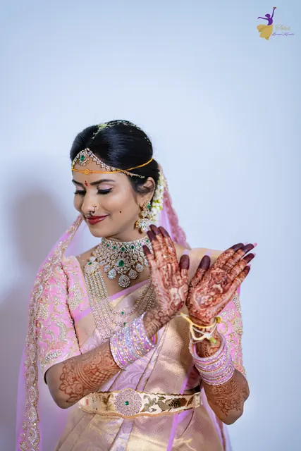 Bride showing her mehendi hands in a pink silk saree, Telugu wedding portrait