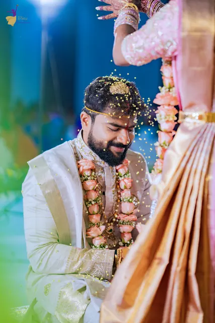 Talambralu: rice falling over the smiling groom in a flower garland