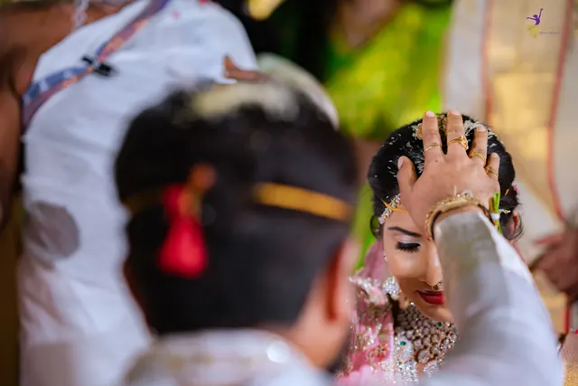 Over the groom’s shoulder: jeelakarra bellam placed on the bride’s head
