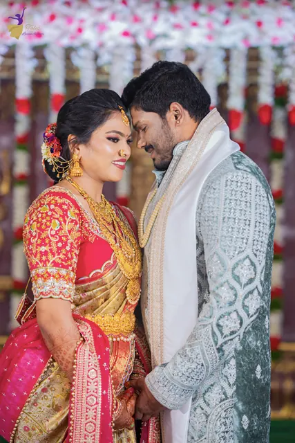 Anuhya in a red and gold silk saree and Ravinder in a pale blue sherwani leaning in close, Telugu wedding Hyderabad