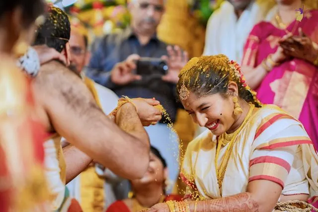Hands and faces during a turmeric wedding ritual, Hyderabad