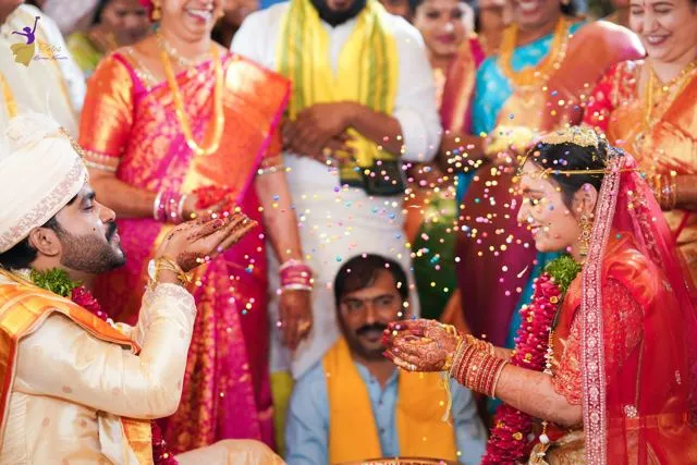 Family gathered around a seated groom in blue, wedding ritual