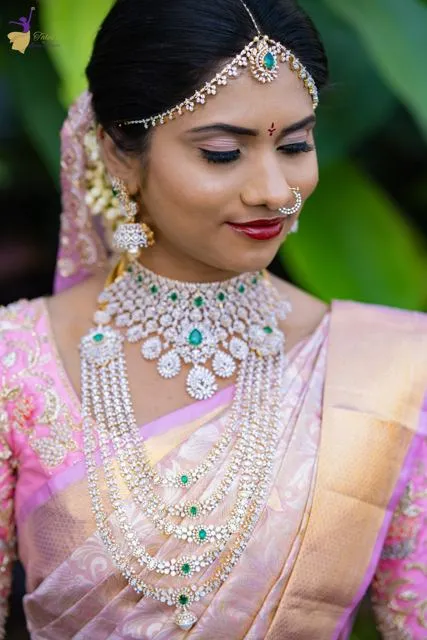 Bridal portrait with layered diamond and emerald jewellery, lavender saree