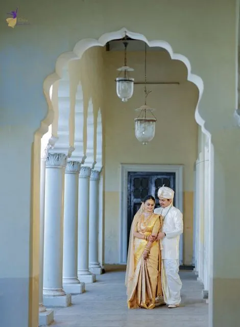 Couple framed in a temple-style arched hallway, Telugu wedding, Hyderabad