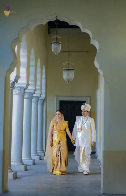 Couple walking a white arched corridor with pillars